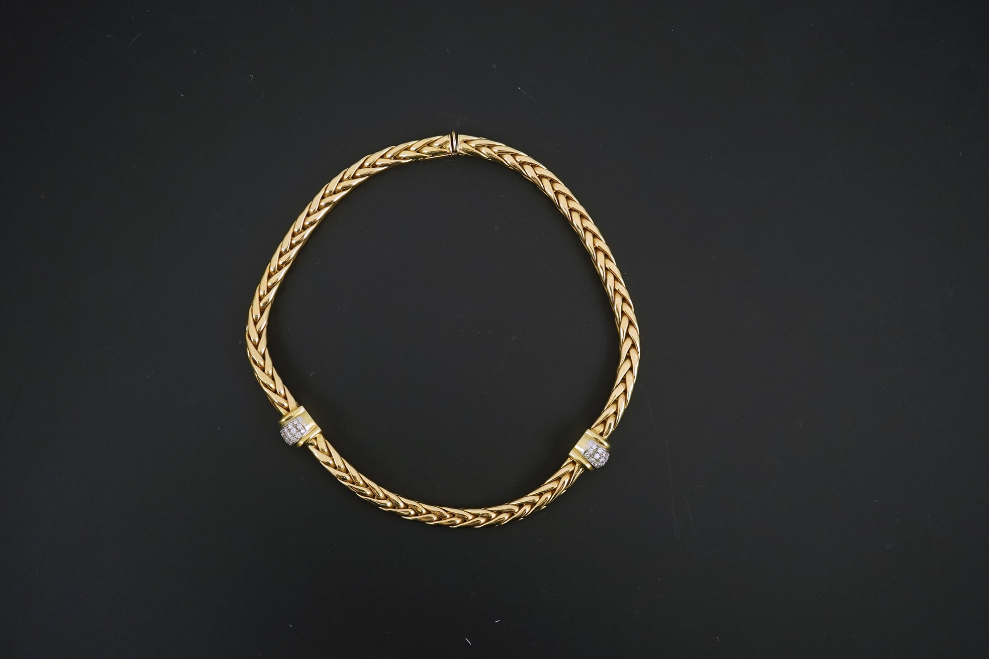 A modern Mappin & Webb 18ct gold interwoven link necklace, with two pave set diamond bands